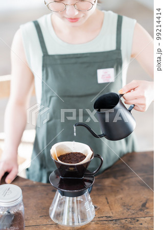 コーヒーケトルでドリップコーヒーをいれる若い女性店員　顔無し 99214414