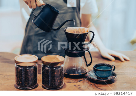コーヒーケトルでドリップコーヒーをいれる若い女性店員 顔無し コーヒーケトルでドリップコーヒーをいれる若い女性店員 顔無し 99214417