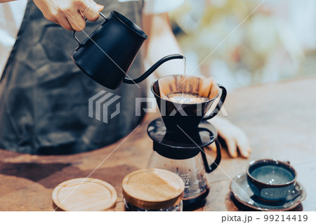 コーヒーケトルでドリップコーヒーをいれる若い女性店員　顔無し 99214419