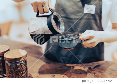 コーヒーをカップに入れるアルバイトの手元 99214421