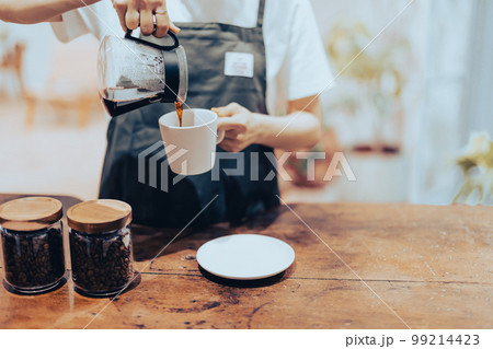 コーヒーをカップに入れるアルバイトの手元 99214423
