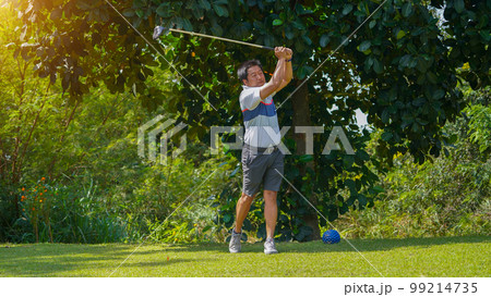 Golfer playing golf in the evening golf course, on sun set evening time 99214735