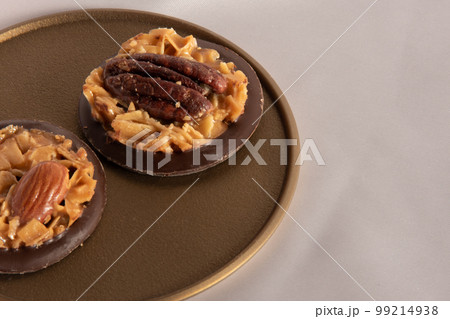 金色のトレーに載せたチョコフロランタンのクローズアップ　ピンクの背景 99214938