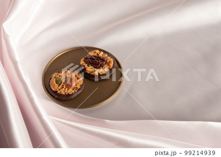 金色のトレーに載せたチョコフロランタン　ピンクの背景 99214939