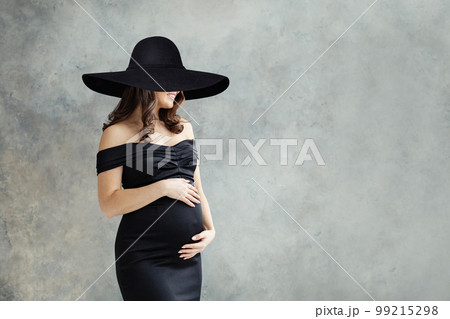 Cheerful pregnant woman in wide black broad brim hat portrait. Cheerful pregnant woman in wide black broad brim hat portrait. 99215298