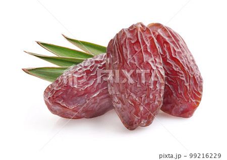 Dates fruit with leaves in closeup on white background Dates fruit with leaves in closeup on white background 99216229