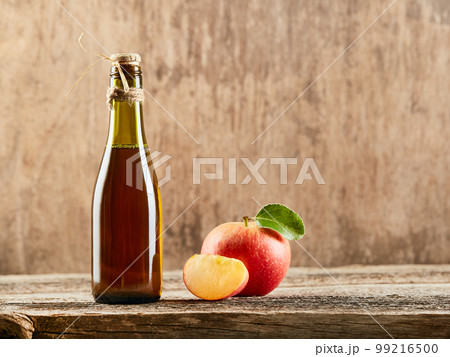 Apple vinegar cider with apple fruits on old wooden background. Fermented product Apple vinegar cider with apple fruits on old wooden background. Fermented product 99216500