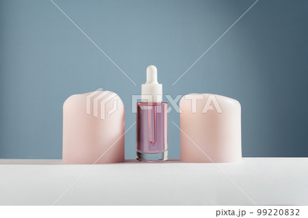 Pink face and hair oil with candles on blue background 99220832