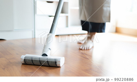 Woman vacuuming the floor of her living room, Big cleaning in the house, Removes germs and dirt and deep stains, Housewife cleaning, Keeping her home clean, Domestic hygiene. 99220886