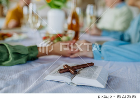 Close-up of family holding hands, praying before Easter lunch. 99220898