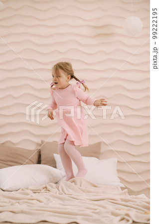 Morning of little girl in a comfortable bedroom. Happy child girl having fun and plays in bed Morning of little girl in a comfortable bedroom. Happy child girl having fun and plays in bed 99222195