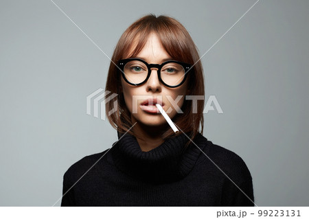 beautiful smoking woman in glasses. girl with cigarette 99223131