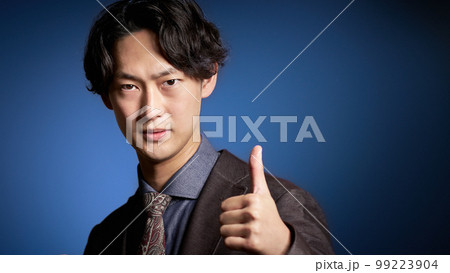 カメラ目線で親指を立てる若いビジネスパーソン 99223904