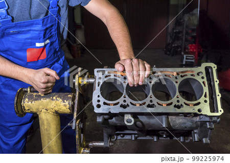 Auto mechanic repairing a cylinder block in a garage. Auto repair concept 99225974