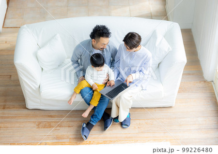 ソファでパソコンを見るファミリー　 99226480