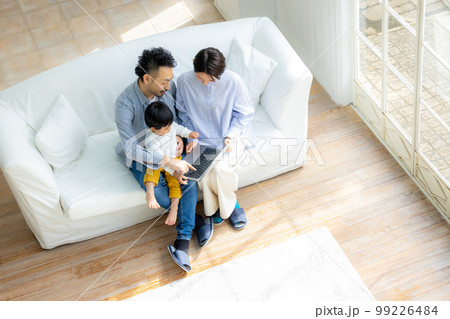 ソファでパソコンを見るファミリー  ソファでパソコンを見るファミリー  99226484