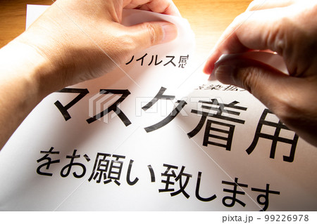 マスク着用緩和イメージ。壁から剥がした「マスク着用のお願い」を破る。 99226978