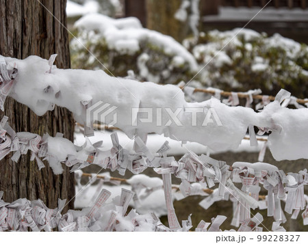 雪が積もった神社のお神籤 99228327