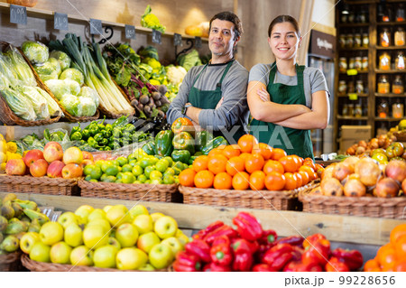 Man and woman sell vegetables and fruits in shop 99228656