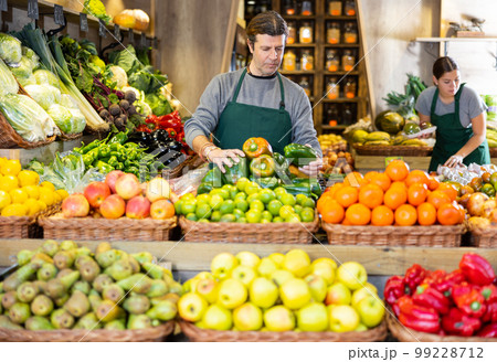 Adult man selling bell peppers in shop Adult man selling bell peppers in shop 99228712