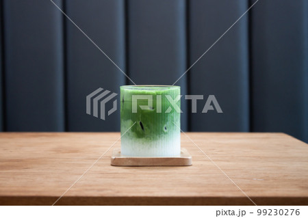 Iced matcha greentea on wooden table Iced matcha greentea on wooden table 99230276