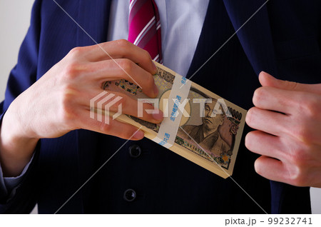 大金を手に持つスーツ姿の男性 99232741