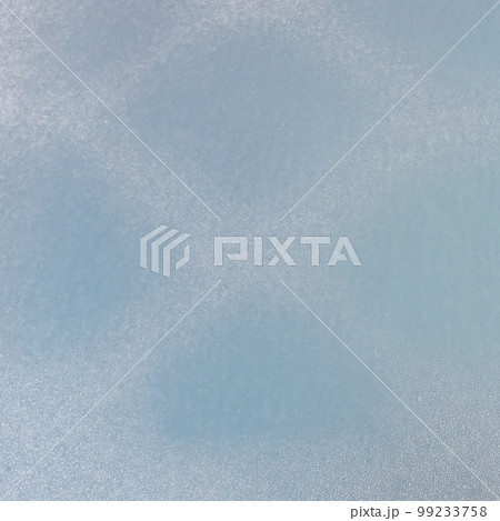 The frozen hood of the car. Frost on the metal surface of the car with a blue blur effect. Abstract background and texture for design. The frozen hood of the car. Frost on the metal surface of the car with a blue blur effect. Abstract background and texture for design. 99233758