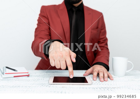 Businessman in Red jacket sitting at table And Pointing With One Finger On Important Message on the mobile phone. Gentleman Showing Critical Announcement. Businessman in Red jacket sitting at table And Pointing With One Finger On Important Message on the mobile phone. Gentleman Showing Critical Announcement. 99234685