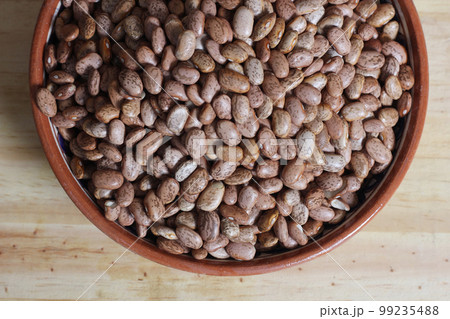 Dry Pinto Beans in Clay Bowl With Wooden Spoon in Rustic Kitchen Dry Pinto Beans in Clay Bowl With Wooden Spoon in Rustic Kitchen 99235488