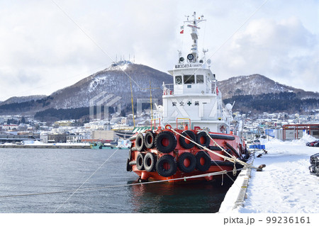 冬の北海道函館市函館港で係留中の大型タグボートと函館山の風景を撮影 冬の北海道函館市函館港で係留中の大型タグボートと函館山の風景を撮影 99236161