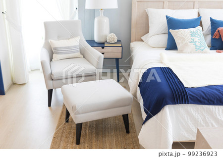 A large double bed with pillows and a bedspread. Lamps with lampshades on the bedside tables.  99236923
