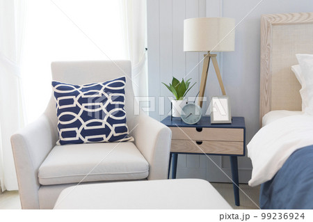 A large double bed with pillows and a bedspread. Lamps with lampshades on the bedside tables.  99236924