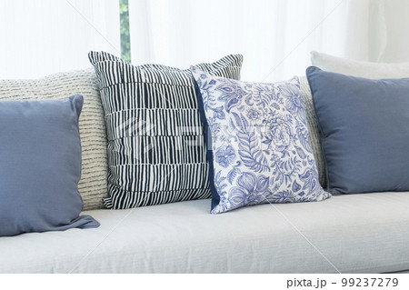 Sofa with flowery and blue rustic pillows in white living room 99237279