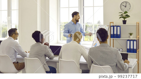 Male office worker is showing his management presentation with data analysis on whiteboard. Male office worker is showing his management presentation with data analysis on whiteboard. 99237717