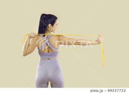 Beautiful woman having fitness workout and doing physical exercises with elastic band 99237722