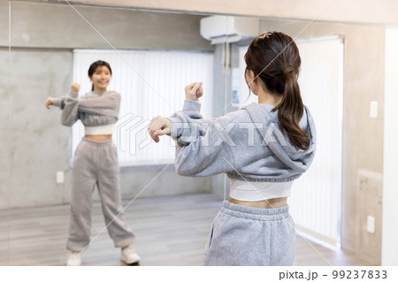 ダンススタジオで鏡に向かってストレッチをする若い女性　ダンス　ヒップホップイメージ 99237833