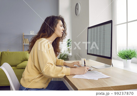 Young business woman accountant working on a pc computer with tables at office or at home. 99237870