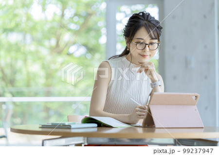 タブレットにペン入力をするビジネスウーマン カジュアルビジネス イメージ タブレットにペン入力をするビジネスウーマン カジュアルビジネス イメージ 99237947