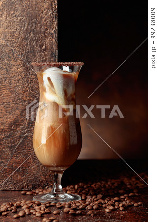 Iced coffee with cream on a brown background. Iced coffee with cream on a brown background. 99238009