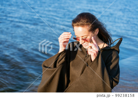 Portrait happy smiling woman on beach. Smiling sensual brunette posing Portrait happy smiling woman on beach. Smiling sensual brunette posing 99238158