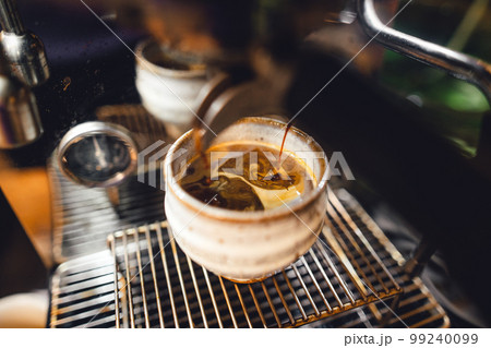 Hot coffee from the machine into the coffee cup Hot coffee from the machine into the coffee cup 99240099