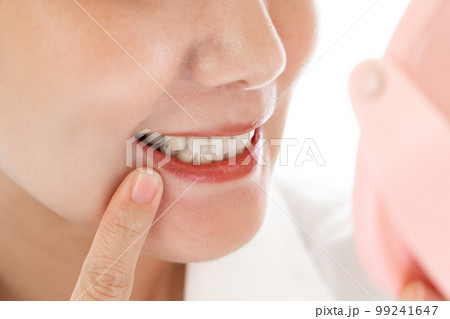 鏡で歯をチェックする日本人女性 99241647