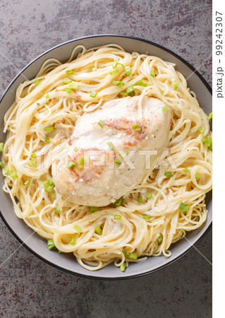 Chicken, cream of chicken soup, cream cheese, butter, broth served over angel hair pasta closeup in the bowl. Vertical top view Chicken, cream of chicken soup, cream cheese, butter, broth served over angel hair pasta closeup in the bowl. Vertical top view 99242307