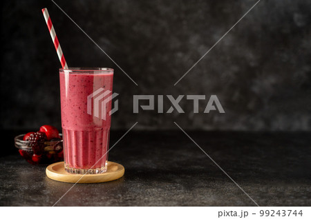 Berry smoothie milk shake drink with fresh fruits. Dark background 99243744