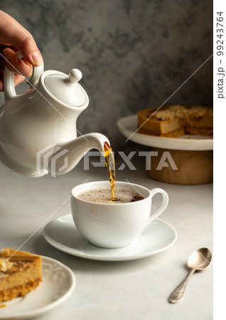 Pouring hot tea in white cup, slow living concept 99243764