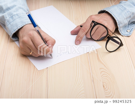 write a letter. In the hands of a man is a ballpoint pen and he writes a letter. write a letter. In the hands of a man is a ballpoint pen and he writes a letter. 99245325