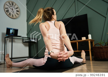 Woman doing sport exercises at home, online classes with trainer using laptop. Sport training and fitness concept. Healthy lifestyle for wellness Woman doing sport exercises at home, online classes with trainer using laptop. Sport training and fitness concept. Healthy lifestyle for wellness 99246391