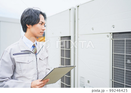 オフィスビルの屋上で業務用エアコンの室外機を点検する若いエンジニアの男性 オフィスビルの屋上で業務用エアコンの室外機を点検する若いエンジニアの男性 99246425