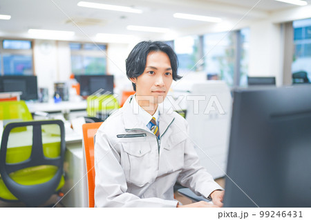作業着を着てパソコン作業をする若いエンジニアの男性 作業着を着てパソコン作業をする若いエンジニアの男性 99246431