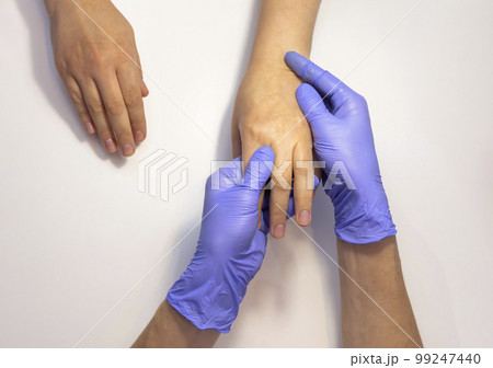 Manicure master applies organic eco peeling on woman hand's skin, doing massage. Nail master wears purple gloves.Nail hand spa treatment, care. Beauty procedure in process. Closeup Horizontal plane. 99247440